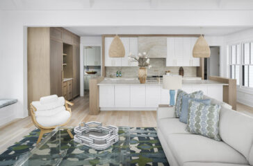 An-open-floor-plan-with-combined-living-and-dining-spaces-features-the-hint-of-a-butler_s-pantry-at-the-back-of-the-kitchen