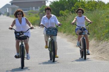 Three women biking on the promenade